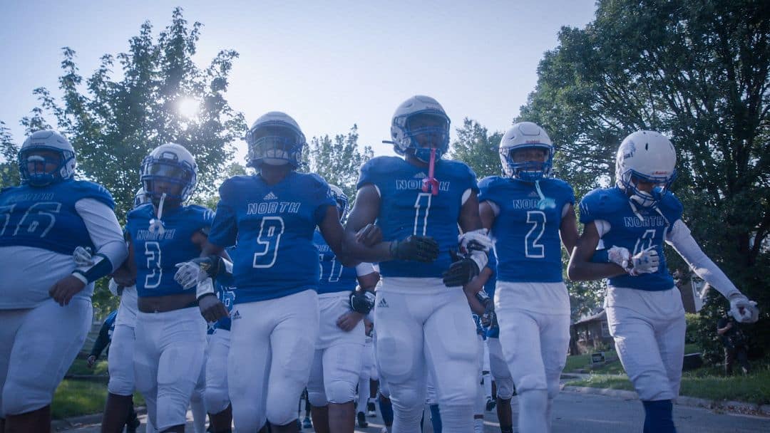 North High Polars players in uniform walk to the field for a football game