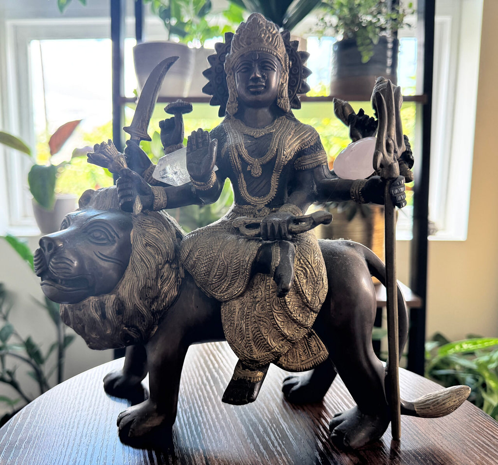 Statue of Goddess Durga seated on a lion holding weapons and symbols of protection and strength