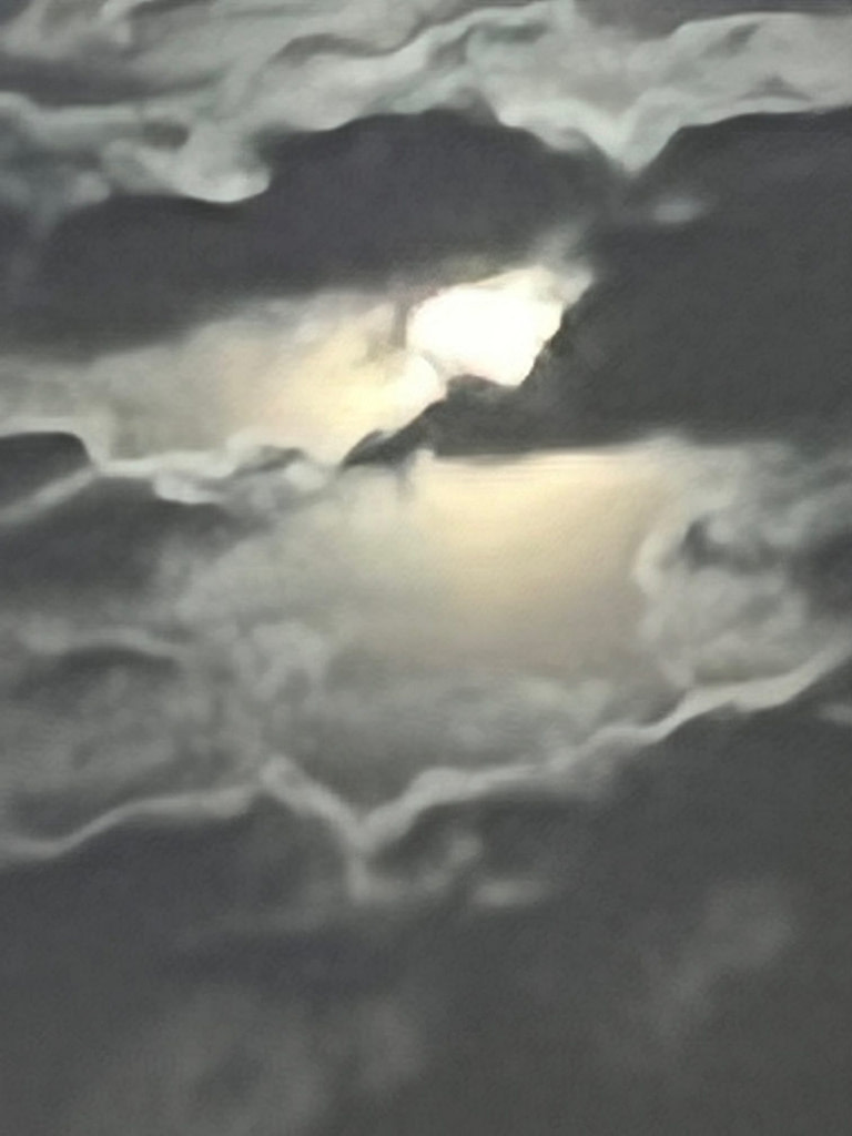 The light of the moon bursts through the clouds